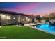 Backyard featuring a well-manicured lawn, a sparkling pool, and a covered patio, ideal for outdoor enjoyment at 3841 E Patrick Ln, Phoenix, AZ 85050