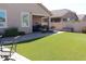 Spacious backyard featuring a covered patio, lush artificial grass, and comfortable seating at 3850 E Balsam Dr, Chandler, AZ 85286