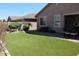 Private backyard with artificial turf, paver patio and a cozy stone fire pit at 3850 E Balsam Dr, Chandler, AZ 85286