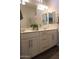 Bathroom featuring dual sinks, large mirror, and modern light fixtures at 3850 E Balsam Dr, Chandler, AZ 85286