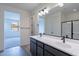 Bathroom featuring a double sink vanity, large mirror, and modern lighting at 39965 W Bunker Dr, Maricopa, AZ 85138