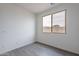 Well-lit bedroom features durable wood-style flooring and a large window at 39965 W Bunker Dr, Maricopa, AZ 85138