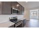 Modern kitchen with stainless steel appliances, white backsplash, and stylish dark cabinetry at 39965 W Bunker Dr, Maricopa, AZ 85138