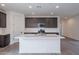 Open-concept kitchen with an island, stainless steel appliances, and modern cabinetry at 39965 W Bunker Dr, Maricopa, AZ 85138