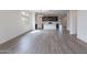 Spacious open-concept living area with lots of natural light and modern gray wood flooring at 39965 W Bunker Dr, Maricopa, AZ 85138
