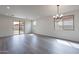Bright living room with sliding glass door, wood-style flooring, and recessed lights at 39965 W Bunker Dr, Maricopa, AZ 85138