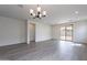 Spacious living room boasts hardwood flooring, recessed lighting, and modern chandelier at 39965 W Bunker Dr, Maricopa, AZ 85138