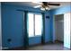 Cozy bedroom with blue walls, tiled flooring, and a window with natural light at 4116 N 78Th Ave, Phoenix, AZ 85033