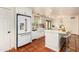 White kitchen boasts modern appliances, a large island with seating, and terracotta tile flooring at 4314 E Montecito Ave, Phoenix, AZ 85018