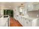 The kitchen features terracotta floors, white cabinets with brass hardware, a white fridge, and quartz countertops at 4314 E Montecito Ave, Phoenix, AZ 85018