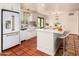 Bright kitchen features white cabinets, terra cotta tile flooring, and a large central island with bar seating at 4314 E Montecito Ave, Phoenix, AZ 85018