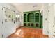 Bright living room showcasing terracotta floors, a front door with a window, and a green built-in bookcase at 4314 E Montecito Ave, Phoenix, AZ 85018