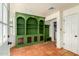 Living room with terracotta floors, a green bookcase, and white walls that bring brightness into the room at 4314 E Montecito Ave, Phoenix, AZ 85018