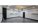 Epoxy floored garage with an automatic door, an access door, shelving, and mini-split AC at 5311 W Fulton St, Phoenix, AZ 85043