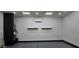 Spacious garage featuring durable epoxy flooring, shelving, and an efficient mini-split AC unit at 5311 W Fulton St, Phoenix, AZ 85043