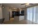 Modern kitchen with stainless appliances, dark cabinets, a tiled backsplash, and an adjacent dining area with sliding glass doors at 5311 W Fulton St, Phoenix, AZ 85043