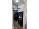 Well-lit laundry room with shelving and side-by-side navy washer and dryer at 5311 W Fulton St, Phoenix, AZ 85043