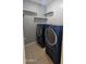 Functional laundry room with modern, front-load washer and dryer, shelving, and neutral-colored tile flooring at 5311 W Fulton St, Phoenix, AZ 85043