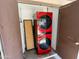 View of laundry area with red washer and dryer unit, water heater, and metal doors at 555 N May -- # 1, Mesa, AZ 85201