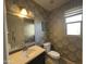 Stylish powder room with patterned wallpaper, vanity, and framed mirror at 6506 S 50Th Ln, Laveen, AZ 85339