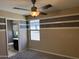 Bedroom with view to attached bathroom; features striped accent wall and fan at 6506 S 50Th Ln, Laveen, AZ 85339