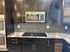 Modern kitchen featuring stainless steel microwave, dark cabinetry, and granite countertops at 6506 S 50Th Ln, Laveen, AZ 85339