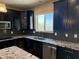 Kitchen features dark cabinets, stainless steel appliances, granite countertops, and tile backsplash at 6506 S 50Th Ln, Laveen, AZ 85339