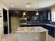 Spacious kitchen with dark cabinetry, granite countertops, stainless appliances, and a central island at 6506 S 50Th Ln, Laveen, AZ 85339