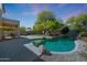 Beautiful backyard pool with a rock waterfall feature, spacious patio, and well-maintained lawn at 7336 E Overlook Dr, Scottsdale, AZ 85255