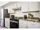 Bright kitchen featuring granite countertops, stainless steel appliances, and white cabinets at 7336 E Overlook Dr, Scottsdale, AZ 85255
