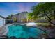 A luxurious swimming pool with rock features and mature trees behind the house at 7336 E Overlook Dr, Scottsdale, AZ 85255