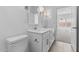 Bright bathroom showcasing a double vanity with modern fixtures, adjacent to a doorway leading into the bedroom at 7643 W Park St, Laveen, AZ 85339
