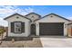 Charming single-story home featuring a two-car garage, neutral stucco, and manicured desert landscaping at 7643 W Park St, Laveen, AZ 85339