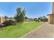 Expansive backyard with lush lawn, a willow tree, and gravel landscaping at 809 S 120Th Ave, Avondale, AZ 85323