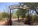 Entrance to a charming Desert Garden path with a decorative metal sign above at 9204 N 106Th Way, Scottsdale, AZ 85258