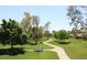 Beautiful park landscape with a winding path, green grass, and mature trees under a clear sky at 9204 N 106Th Way, Scottsdale, AZ 85258