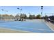 Well-lit outdoor tennis courts with players, nets, and surrounding green landscape at 9204 N 106Th Way, Scottsdale, AZ 85258