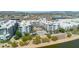 Aerial view shows a community pool nestled between waterfront condos, surrounded by palm trees and native landscaping at 945 E Playa Del Norte Dr # 1003, Tempe, AZ 85288