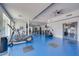 On blue flooring, exercise equipment includes treadmills, weight machines, and free weights in a well-lit, mirrored gym at 945 E Playa Del Norte Dr # 1003, Tempe, AZ 85288