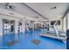 Weight machines and treadmills on blue floor in a well-lit exercise gym with mirrors at 945 E Playa Del Norte Dr # 1003, Tempe, AZ 85288