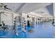 Weight machines and free weights on blue flooring in a well-lit exercise gym at 945 E Playa Del Norte Dr # 1003, Tempe, AZ 85288