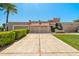 Charming single-story home featuring a large driveway, mature landscaping, and a three-car garage, with a tile roof at 9847 E Michigan Ave, Sun Lakes, AZ 85248