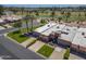 Overhead shot showcases a single-Gathering home with a three-car garage and verdant landscaping bordering a golf course at 9847 E Michigan Ave, Sun Lakes, AZ 85248