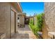 The side exterior features a tiled walkway, desert landscaping, and a beige textured wall, ensuring privacy and style at 9847 E Michigan Ave, Sun Lakes, AZ 85248