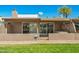 Exterior view of the home showing the patio, well-maintained lawn, and community landscaping at 9847 E Michigan Ave, Sun Lakes, AZ 85248