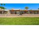 Back exterior of the home showcasing the patio, hot tub, and a beautifully maintained green space at 9847 E Michigan Ave, Sun Lakes, AZ 85248