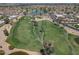 Wide aerial view showcases a golf course with lush green fairways, a tranquil pond, and surrounding residential community at 9847 E Michigan Ave, Sun Lakes, AZ 85248