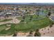 Scenic aerial perspective of a golf course with a serene pond, surrounding homes, and the distant mountain range at 9847 E Michigan Ave, Sun Lakes, AZ 85248
