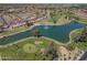 Overhead view of a golf course with a peaceful lake, mature trees, and attractive residential area in the background at 9847 E Michigan Ave, Sun Lakes, AZ 85248