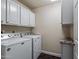 Laundry room area with a washer, dryer, and white cabinets above at 9847 E Michigan Ave, Sun Lakes, AZ 85248